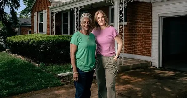 Webster Groves City Council Member Karen Alexander and Webster Groves Community Land Trust Executive Director Farrell Carfield in front of a home in Webster Groves they are helping coordinate and rehabilitate for use in an effort to provide affordable housing in the area.